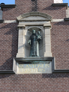 844024 Afbeelding van het bronzen beeld van de Heilige Antonius in de topgevel van het voormalige ...